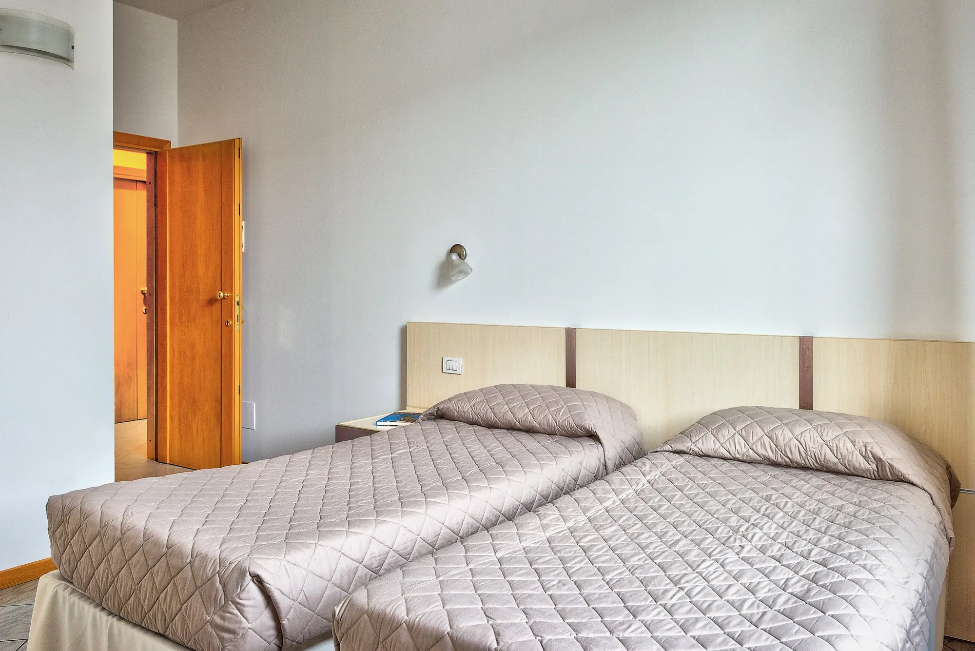 Due letti singoli accostati e porta della camera