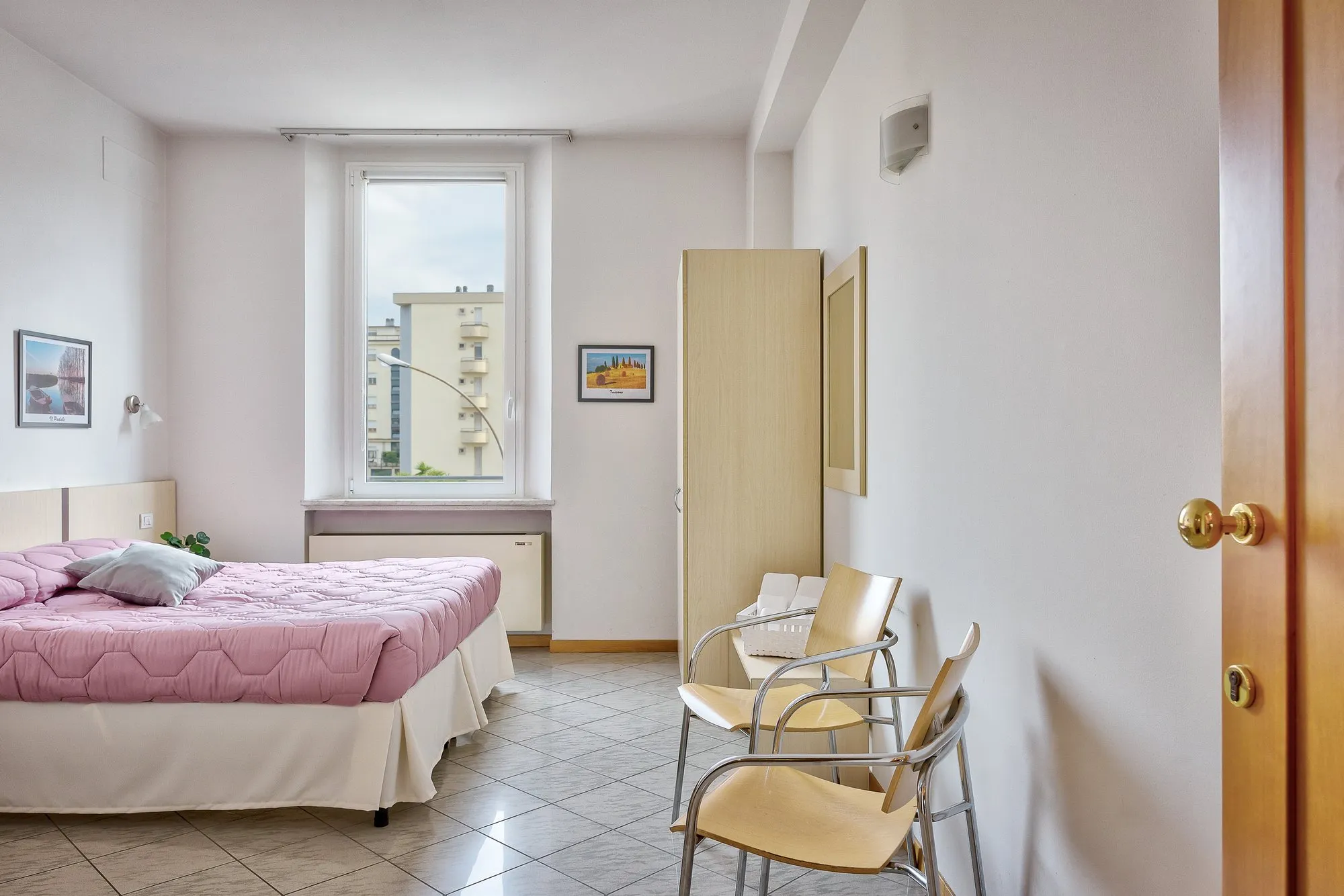 Camera con armadio, sedia e finestra