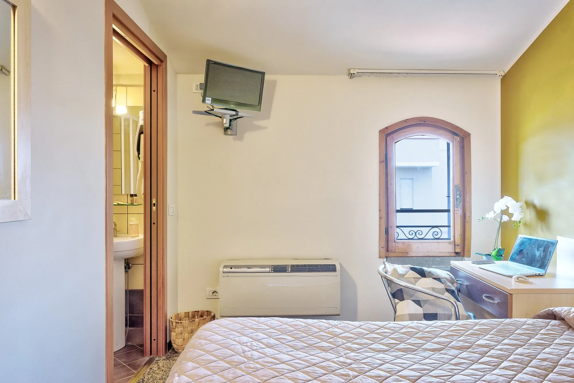 Camera con letto, TV a parete e finestra ad arco