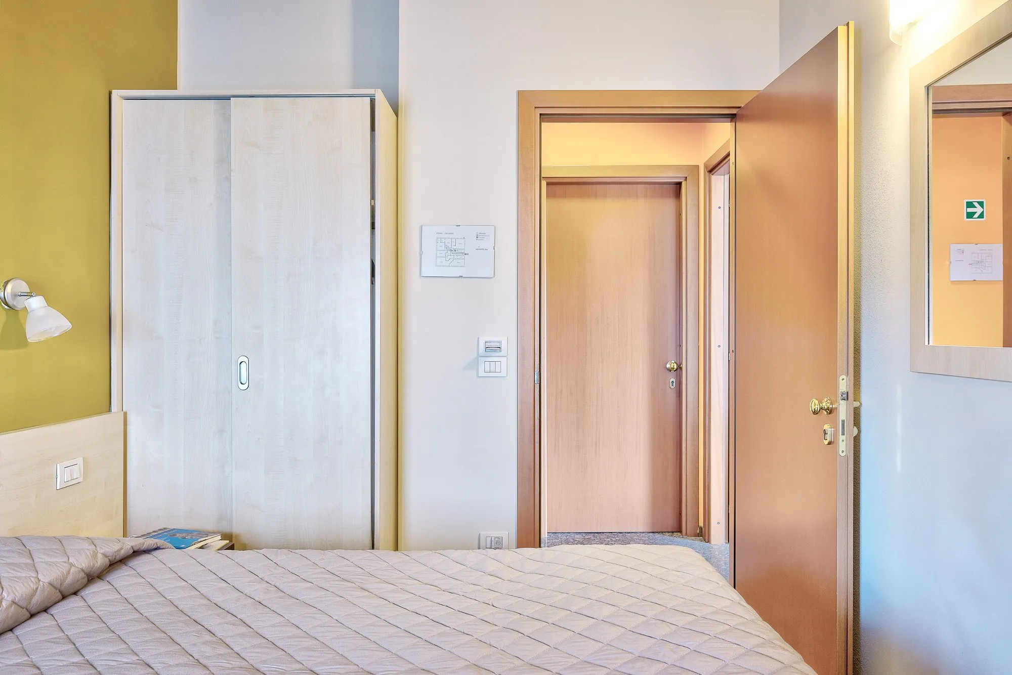 Camera con armadio, letto e porta d'ingresso