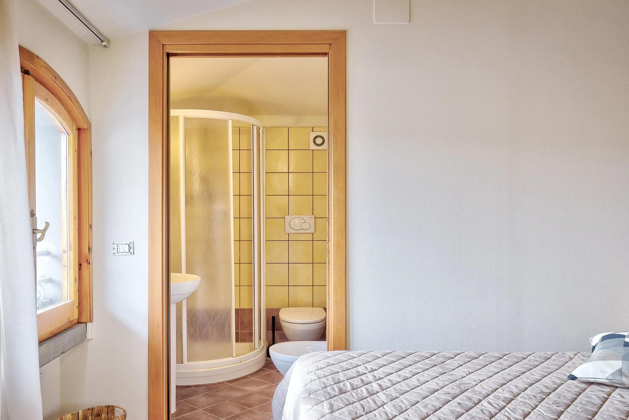 Camera con finestra ad arco e porta del bagno